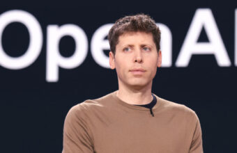 Sam Altman, PDG d'OpenAI, devant le logo de la société.