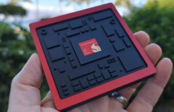 Main tenant une puce Snapdragon 8 Elite rouge et noire.