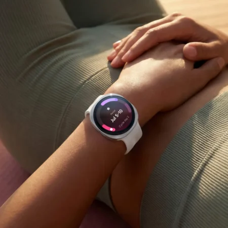 Femme relaxée, montre connectée au poignet, suivi de cycle menstruel.