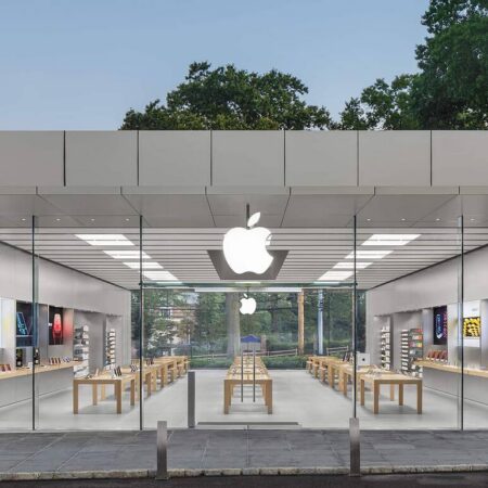 Façade en verre d'un Apple Store moderne, logo lumineux.