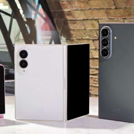Trois smartphones pliables Samsung de différentes couleurs sur une table.