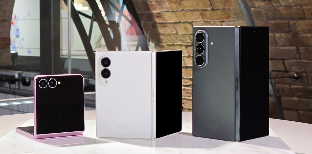 Trois smartphones pliables Samsung de différentes couleurs sur une table.