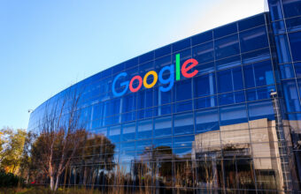 Logo Google coloré sur un bâtiment moderne en verre.