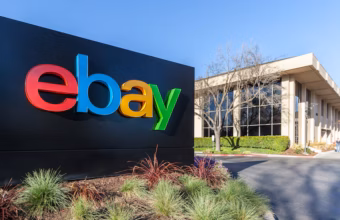 Panneau du logo eBay coloré devant un bâtiment de bureaux.