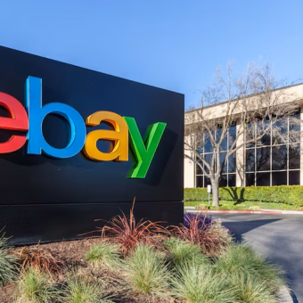 Panneau du logo eBay coloré devant un bâtiment de bureaux.