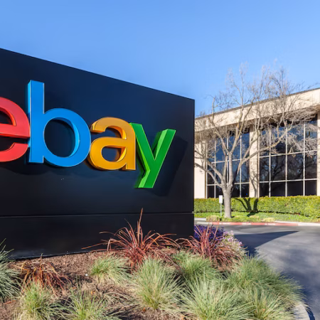 Panneau du logo eBay coloré devant un bâtiment de bureaux.