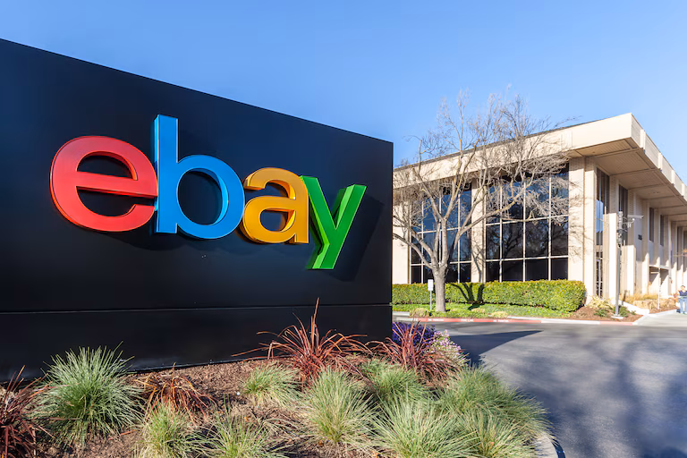 Panneau du logo eBay coloré devant un bâtiment de bureaux.