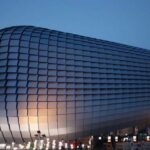 Samsung veut augmenter sa production de RAM de 15 % dès 2026 Bâtiment moderne Samsung avec façade texturée et logo lumineux.