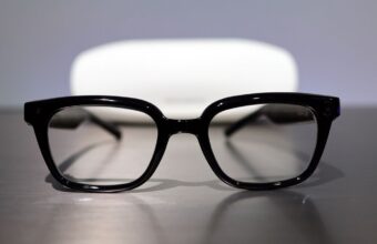 Lunettes intelligentes noires, étui de chargement en arrière-plan.