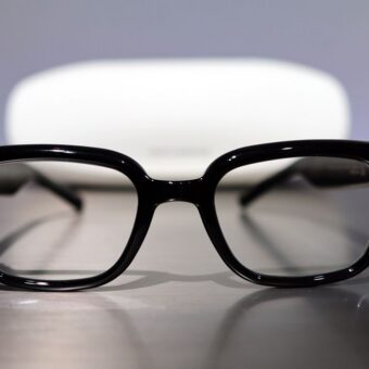 Lunettes intelligentes noires, étui de chargement en arrière-plan.