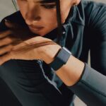 WHOOP et Natural Cycles : un an offert aux nouveaux utilisateurs Femme étirant le bras avec montre connectée de fitness.